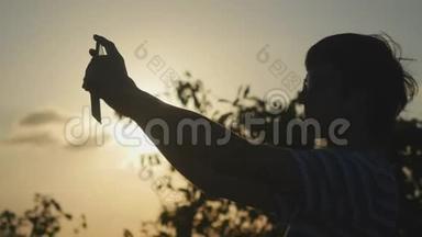 年轻的游客戴着太阳镜在山顶拍摄日落。 3840x2160